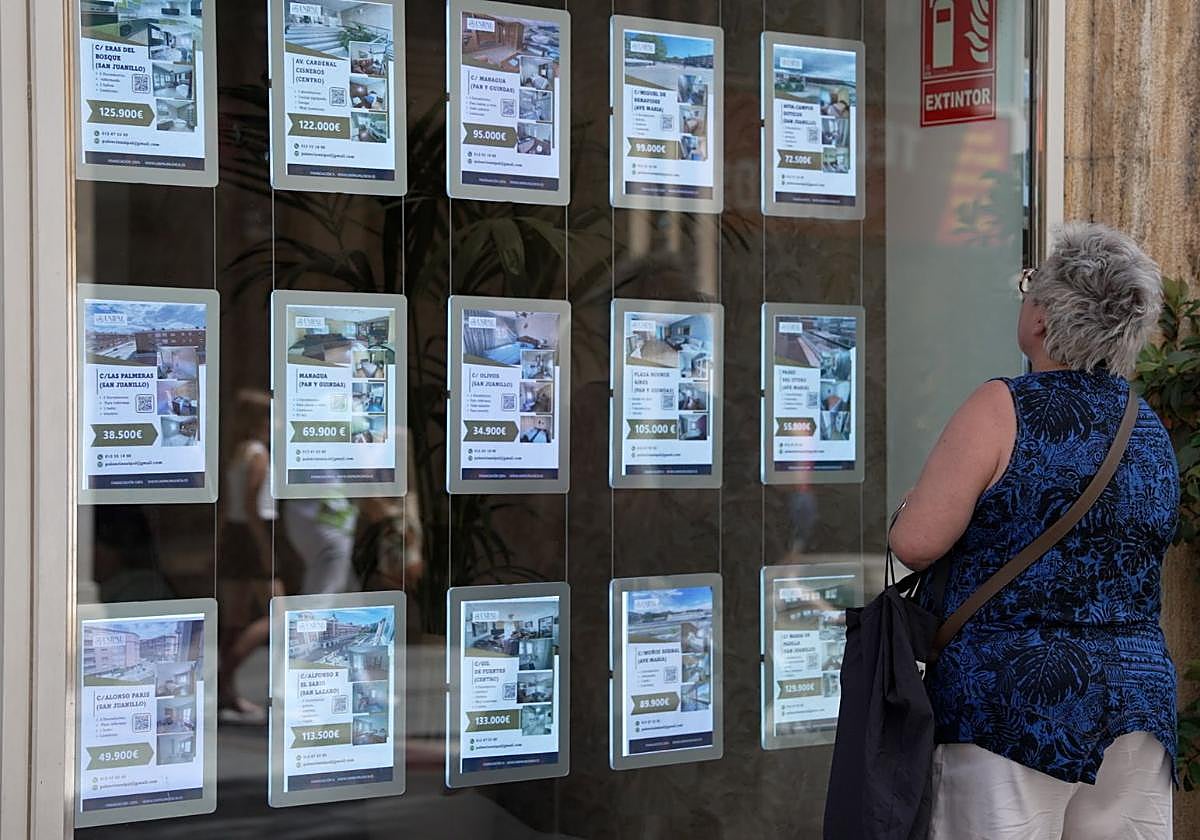 Una mujer observa el escaparate de una agencia de alquiler de viviendas