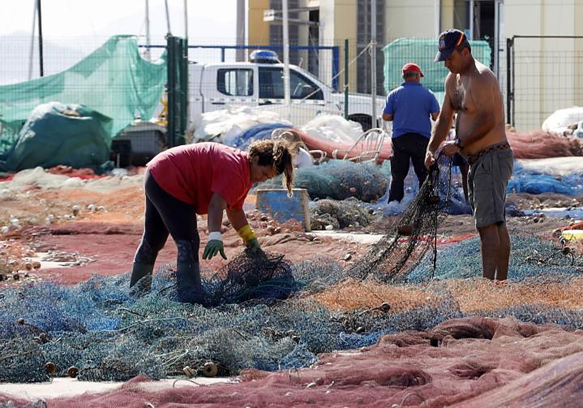 Pescadores en labores de mantenimiento en tierra en una zona mediterránea