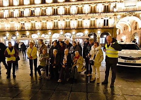 Secondary image 1 - Above these lines, a passerby greets the caravan crossing the Plaza Mayor in Valladolid. Below, participants in this initiative in Salamanca take a photo and taxis cross one of the illuminated streets of Valladolid