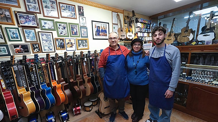 La familia Maldonado posa junto a las fotografías de artistas que han comprado una guitarra de su firma.