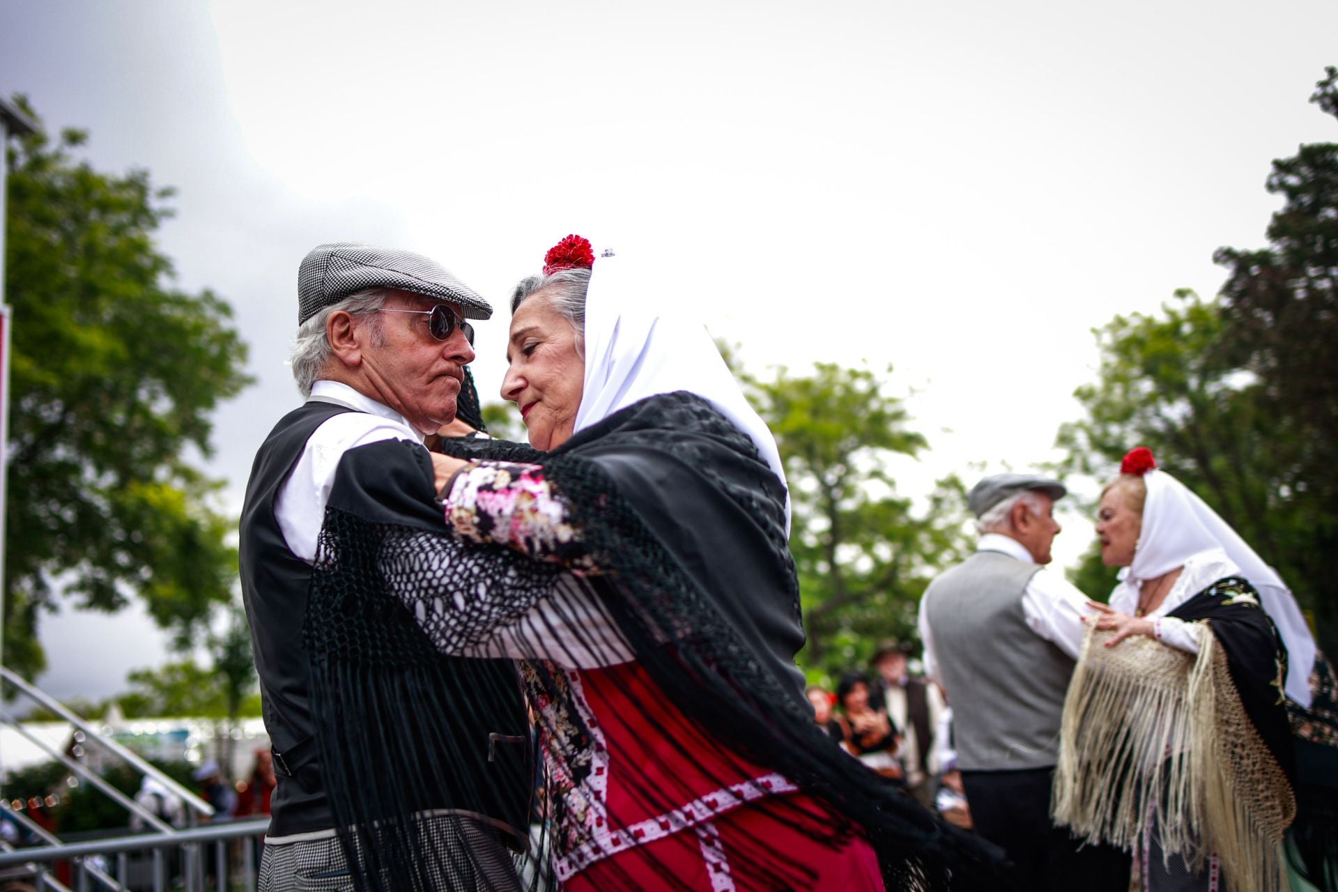 Un grupo de personas bailan un chotis para celebrar San Isidro en la Pradera