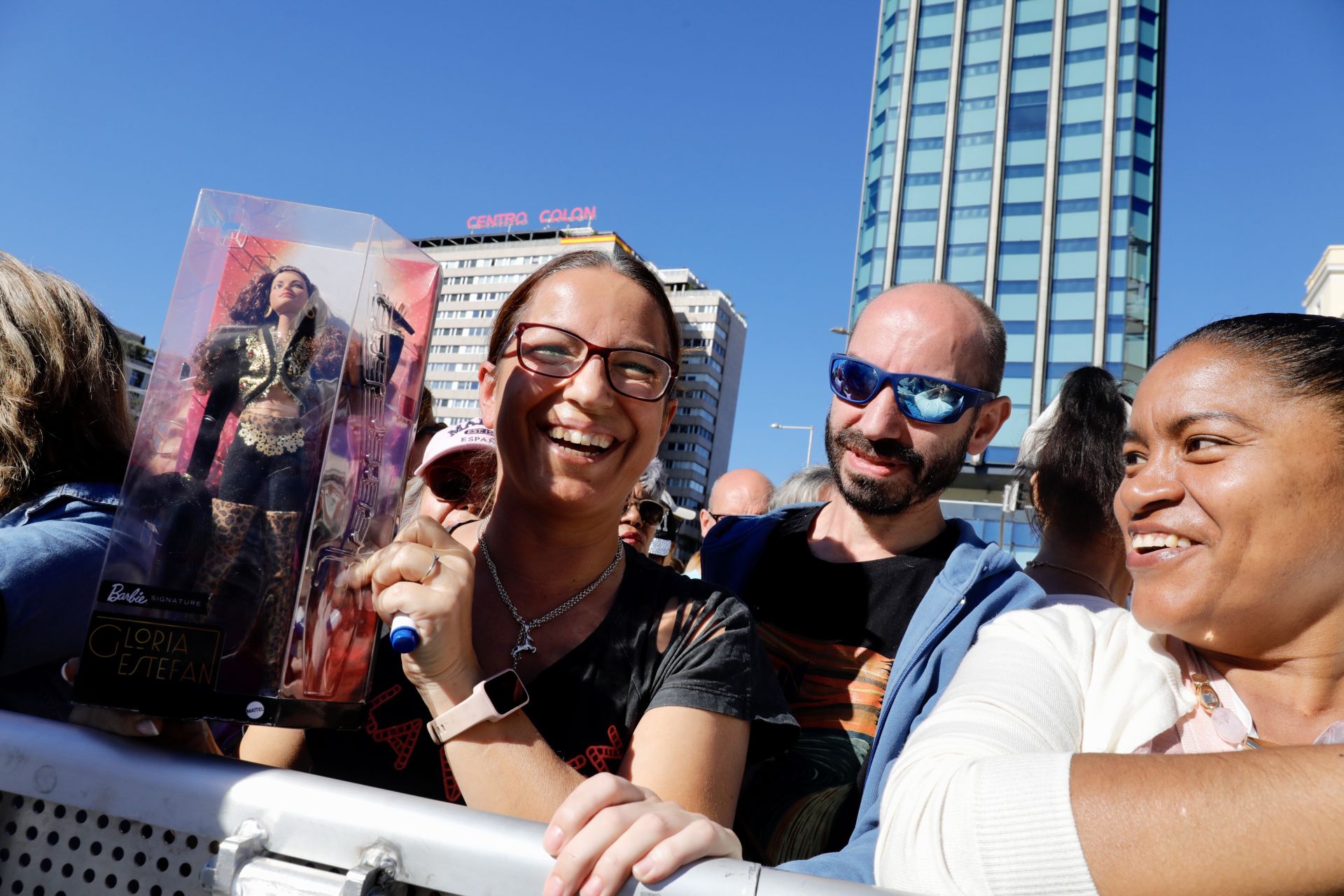 Una asistente al concierto muestra una muñeca de Gloria Estefan