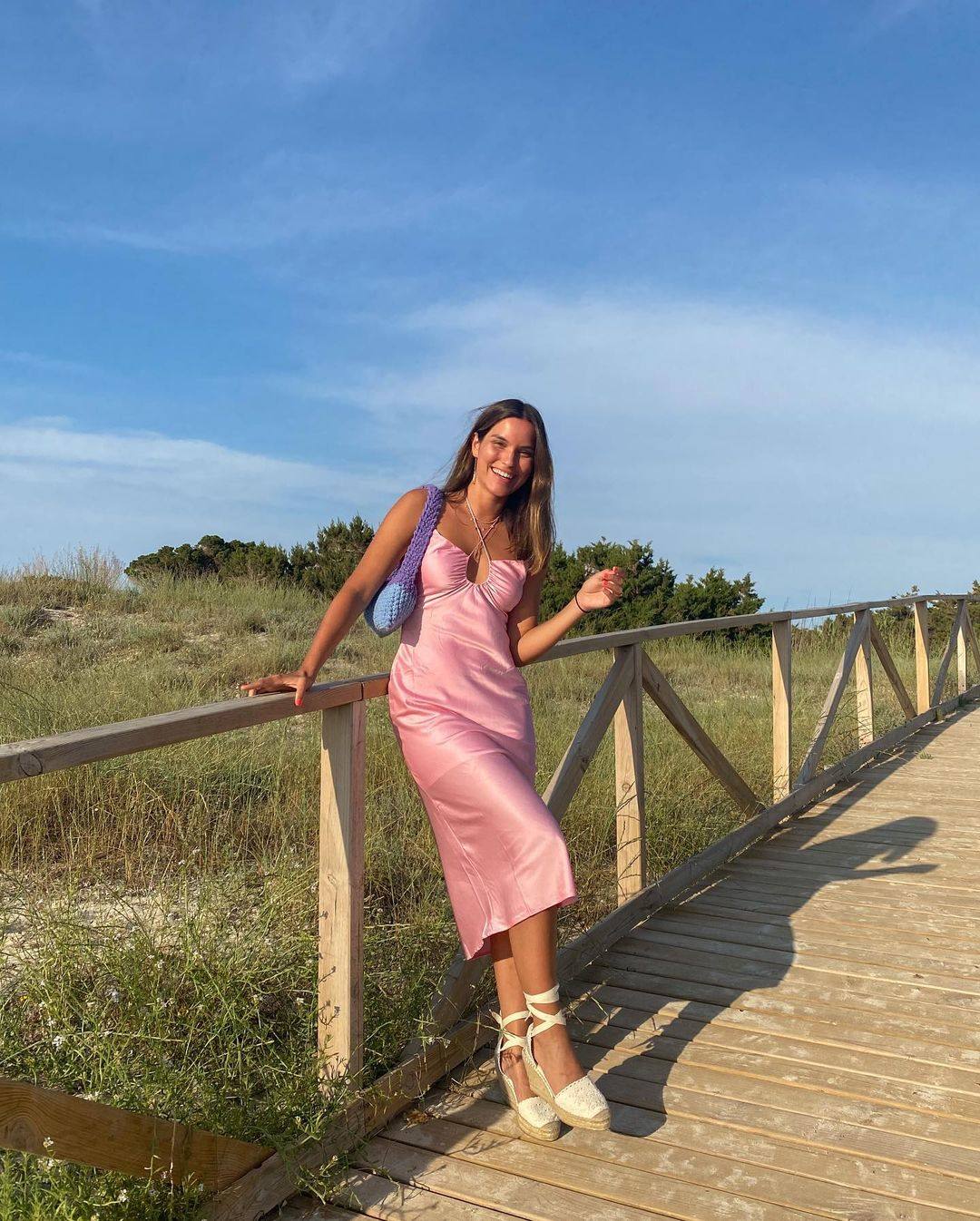 La 'influencer' Carla Di Pinto combina su vestido de satén rosa con unas alpargatas de Vidorreta, con bordados, en tono blanco y anudadas al tobillo.