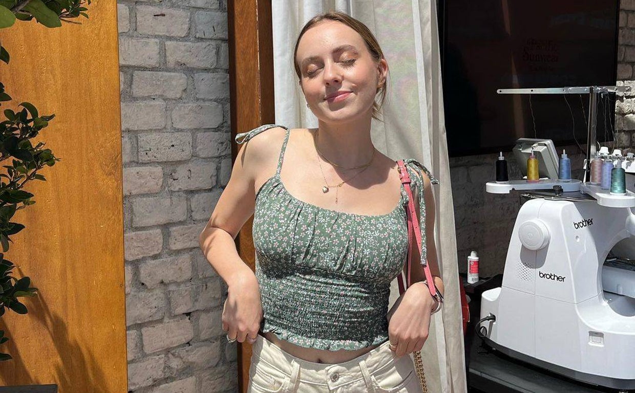 Hannah Warling posando al lado de una máquina de coser