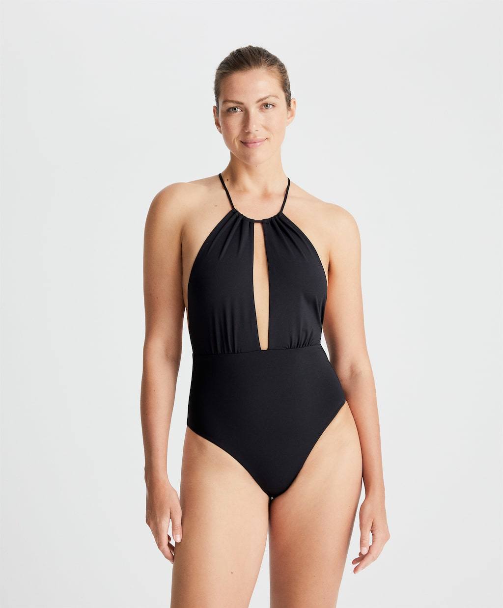 Bañador de Oysho con escote tipo halter abierto. No cuenta con relleno y tiene tirantes finos ajustables en el cuello. La espalda queda al descubierto y la braga es de tipo brasileña. Su precio es de 35,99€