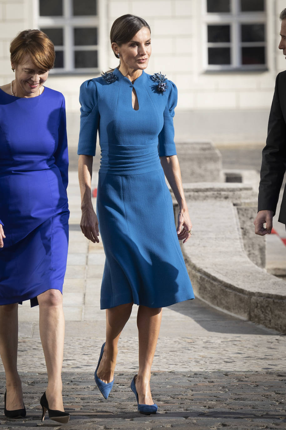 El lunes los reyes acudían al palacio Bellevue donde eran recibidos por el presidente federal, Frank-Walter Steinmeier, y su esposa, Elke Büdenbender. La reina se decantaba por un diseño de Carolina Herrera en uno de sus colores favoritos, el azul klein. Se trata de un vestido de manga corta, hombreras marcadas, cintura marcada y falda con volantes. En los hombres lleva flores del mismo tono.