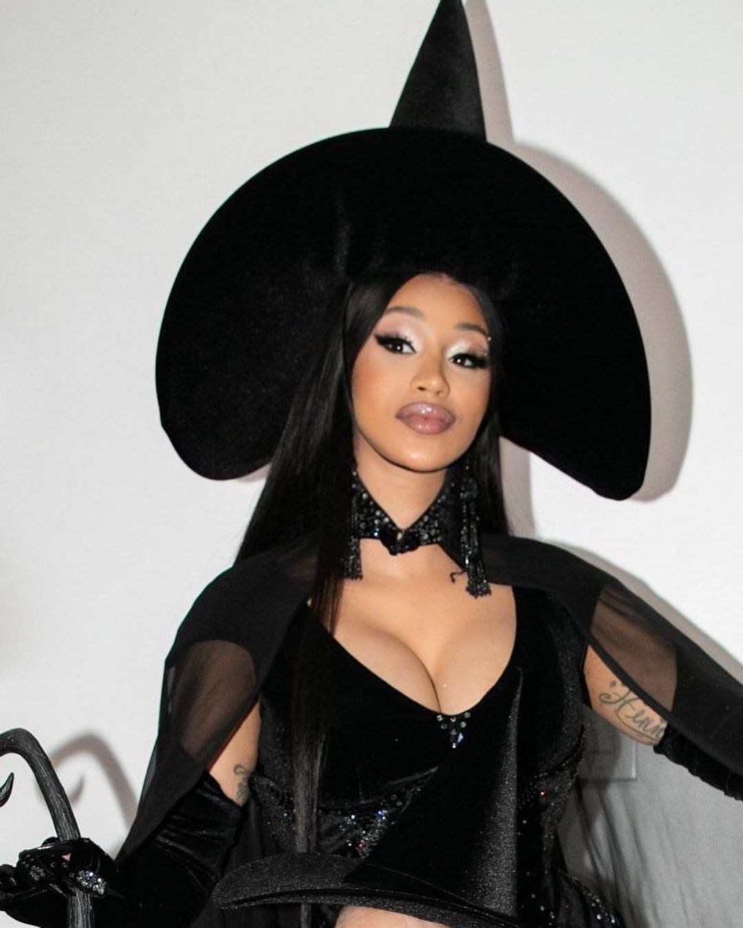 Cardy B, reconocida cantante en todo el mundo, opta en esta fiesta por un disfraz de bruja en color negro al que no le falta detalle.