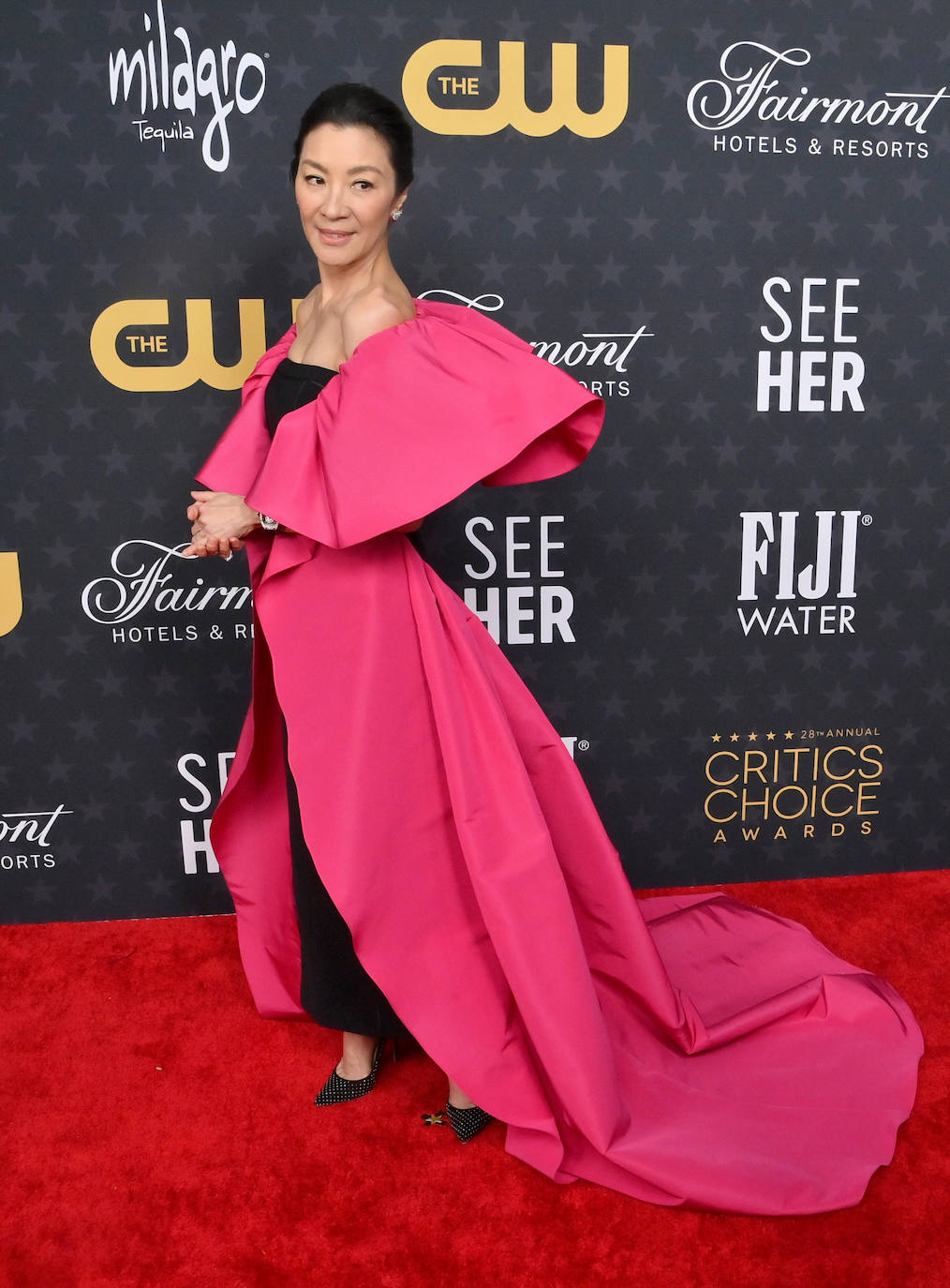 Michelle Yeoh lució un vestido negro, con escote palabra de honor y que llevaba superpuesta una capa rosa de Carolina Herrera.