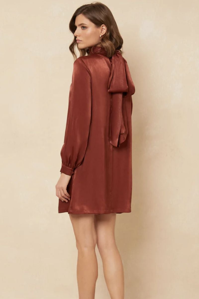 Vestido de Bimani satinado corto de manga larga, abullonada en puño y el cierre del botón forrado. Un modelo por encima de la rodilla con corte oversize y una gran lazada al cuello. Disponible en cinco tonos diferentes. Precio: 149 €.