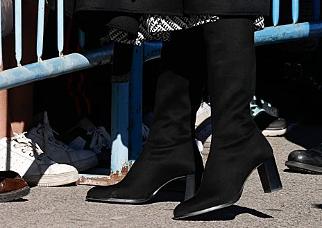 Imagen secundaria 1 - La reina con un estilismo muy elegante formado por abrigo negro, vestido con estampado Príncipe de Gales, y botas altas de ante. 