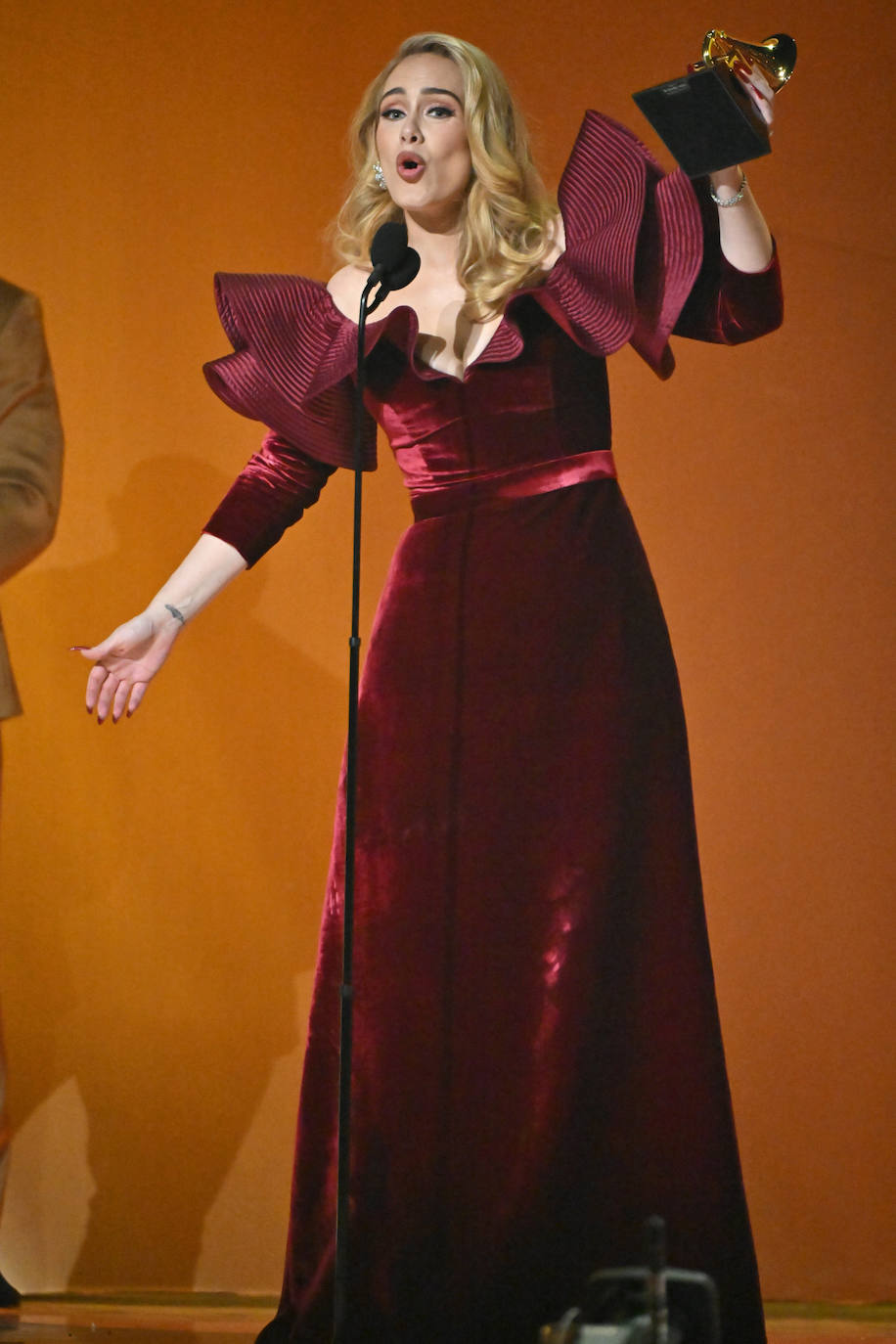 Adele fue una de las ganadoras de la noche. La artista eligió un vestido con volantes de Louis Vuitton en color vino. Lo combinó con melena suelta con ondas y su maquillaje habitual en tonos tierra y con su emblemático eyeliner negro. 