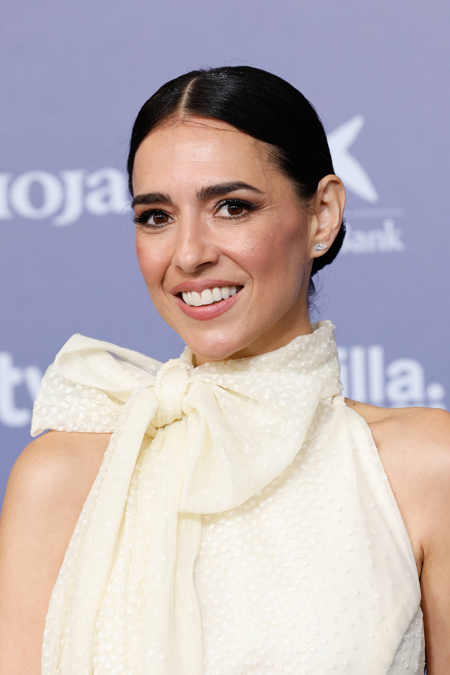 Cristina Brondo eligió un recogido con raya en el medio y acabado wet, que combinó con un maquillaje con sombras doradas, eyeliner negro y labios nude. 