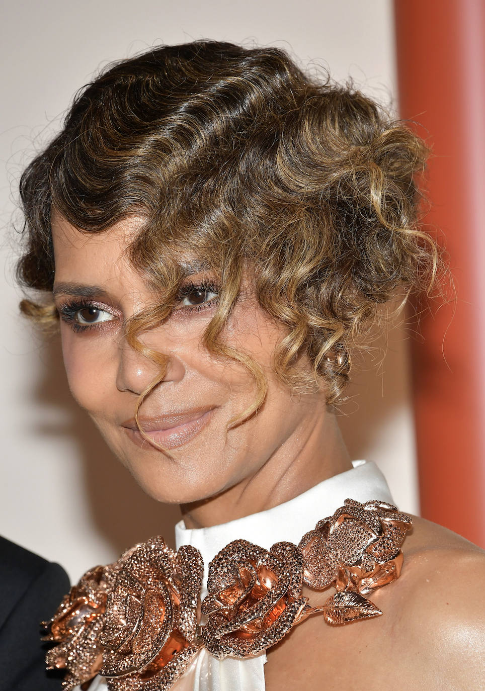 Halle Berry eligió ondas al agua con un look años 20. En cuanto al maquillaje se decantó por sombras doradas y labios nude. 