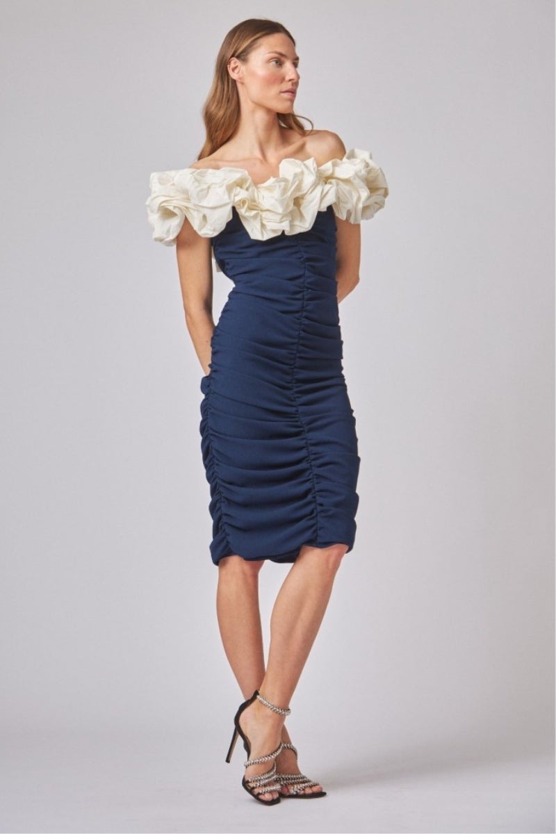 Bodas, bautizos y comuniones. Vestido confeccionado en punto color azul marino escote Bardot con una gran flor beige, de Coosy, perfecto para la época de bodas, bautizos y comuniones. Precio: 125€.