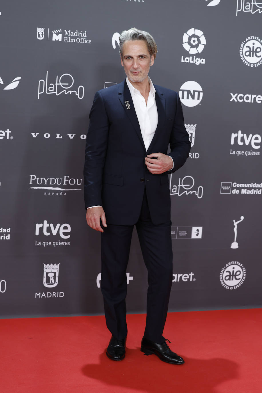 Ernesto Alterio lució un traje con solapa de muesca de lana azul noche de la colección masculina de Dior, una camisa blanca de algodón de cuello clásico y unos derbies negros de cuero.