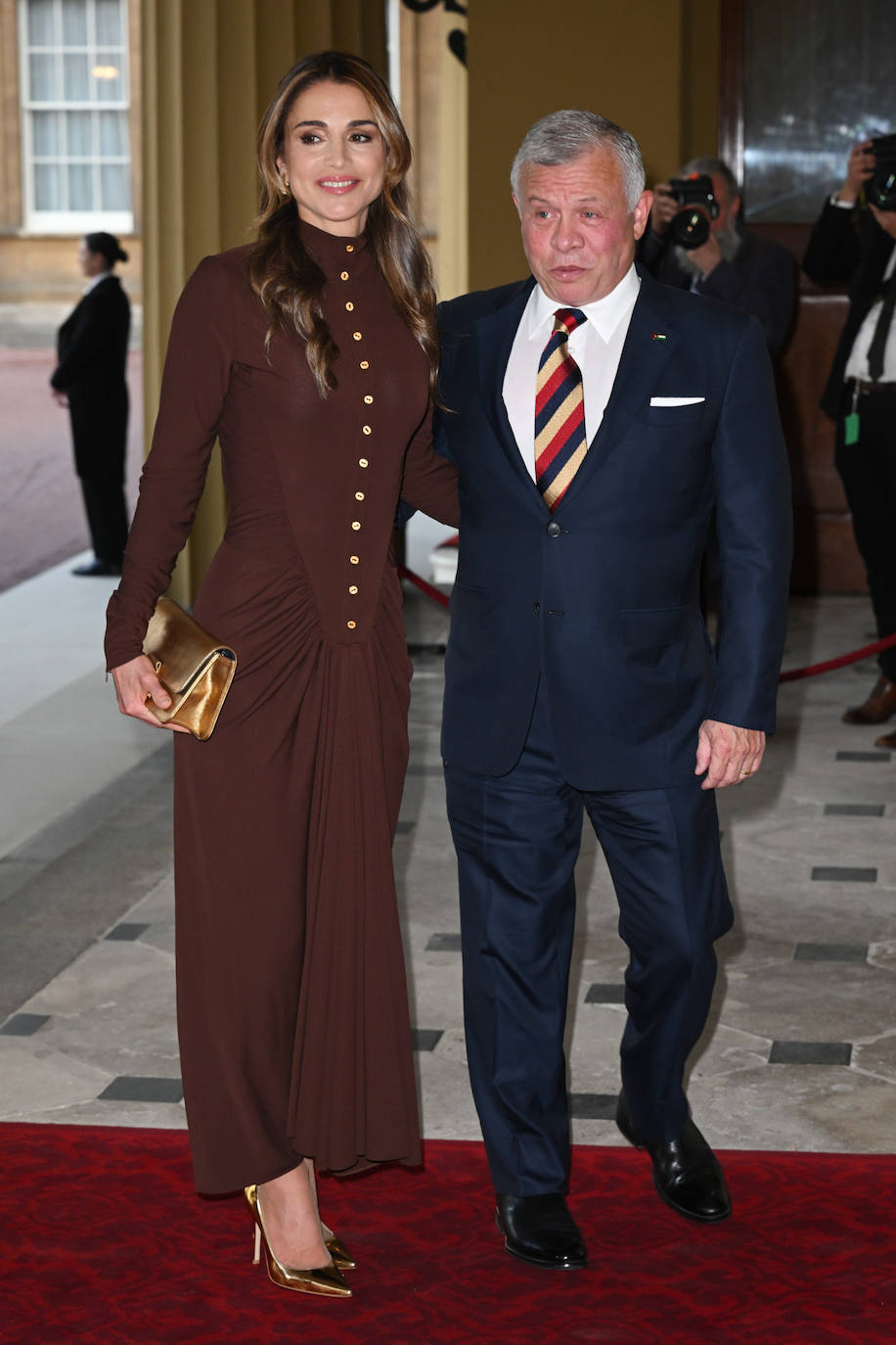 Rania de Jordania con un vestido de Schiaparelli en color marrón que ha combinado con salones y bolso dorados. El bolso es de Dior, y los zapatos de Gianvito Rossi. 