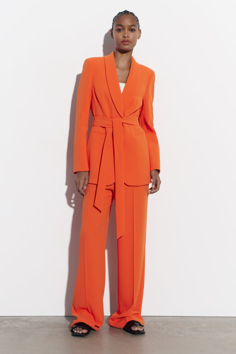 Traje en color naranja de Zara con detalle de lazo en la cintura . Chaqueta 69,95 euros y pantalón 29,95 euros.