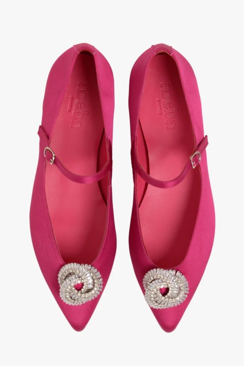 Adeba Madrid. Zapatos Mary Jane modelo 'Knot' confeccionadas en España y hechas con  raso de color fucsia intenso con un llamativo broche de cristales. Poseen una tira en el empeine con una hebilla plateada regulable. Un imprescindible en el armario de las 'insiders'. Precio:  199€.