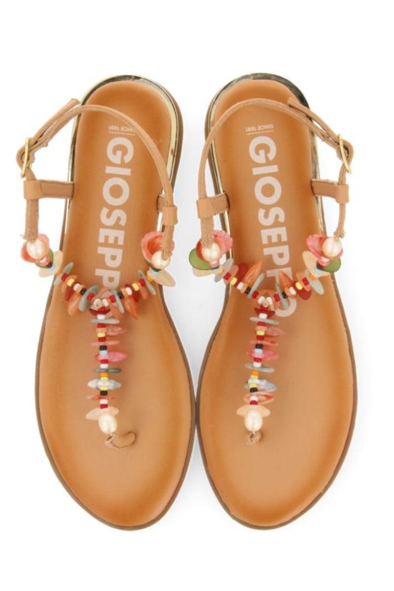 Gioseppo. Sandalias planas étnicas con mini cuña y decoración de conchas multicolor en el empeine. Hippies, cómodas y elegantes. Precio:  59,95€.