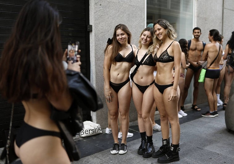 Largas colas en la calle Preciados de Madrid para conseguir ropa gratis.