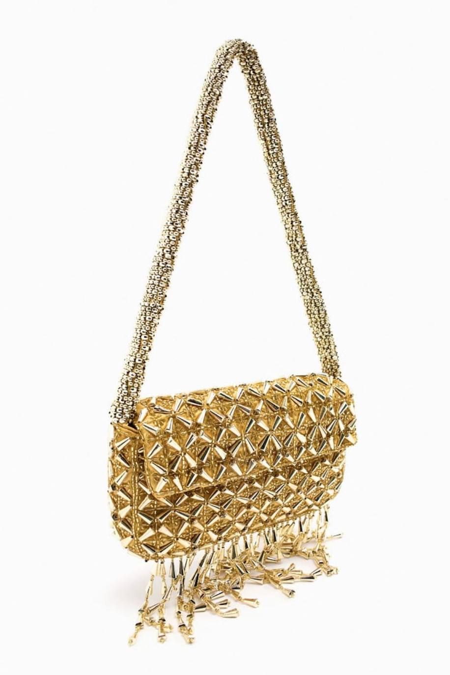 Bolso de hombro en oro con abalorios y flecos. 39.95 euros en Zara.