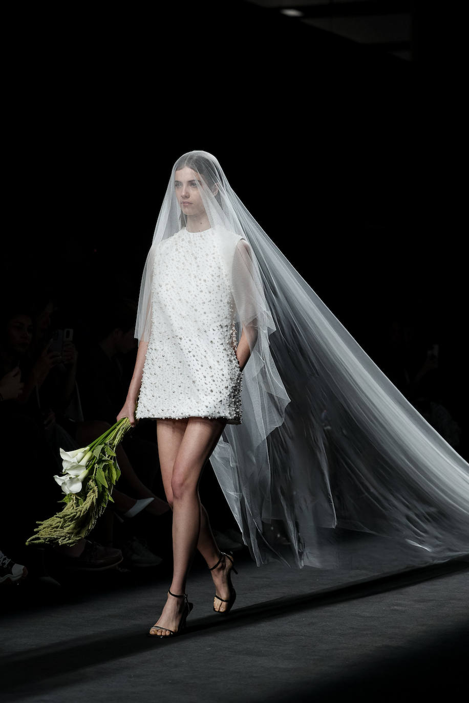 Desfile de Mans en la MBFW Madrid Primavera/Verano 2024. El desfile ha cerrado con una novia mini emperlada entera y velada con tul de seda de más de 5 metros.