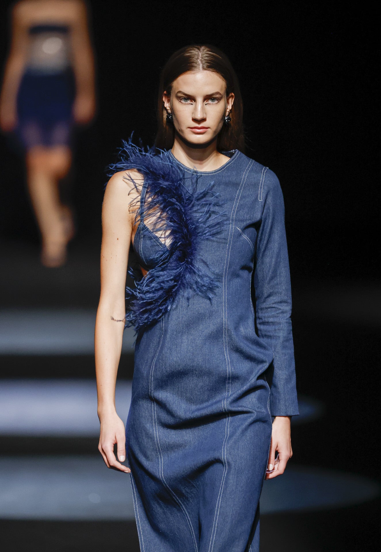 Y tampoco falta el denim en contraste con esta original abertura rematada con plumas. 