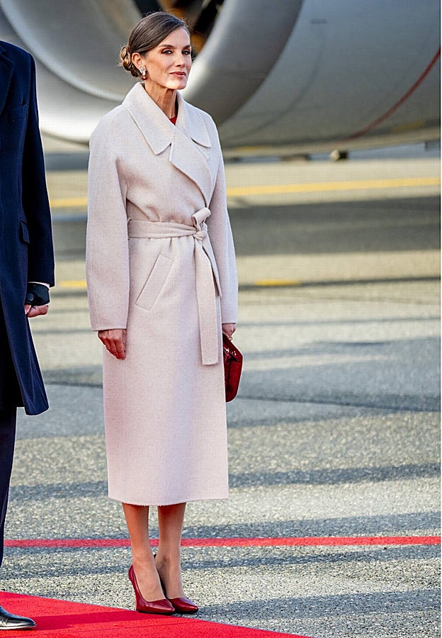 Doña Letizia en Copenhague, con abrigo beige y complementos en color rojo.