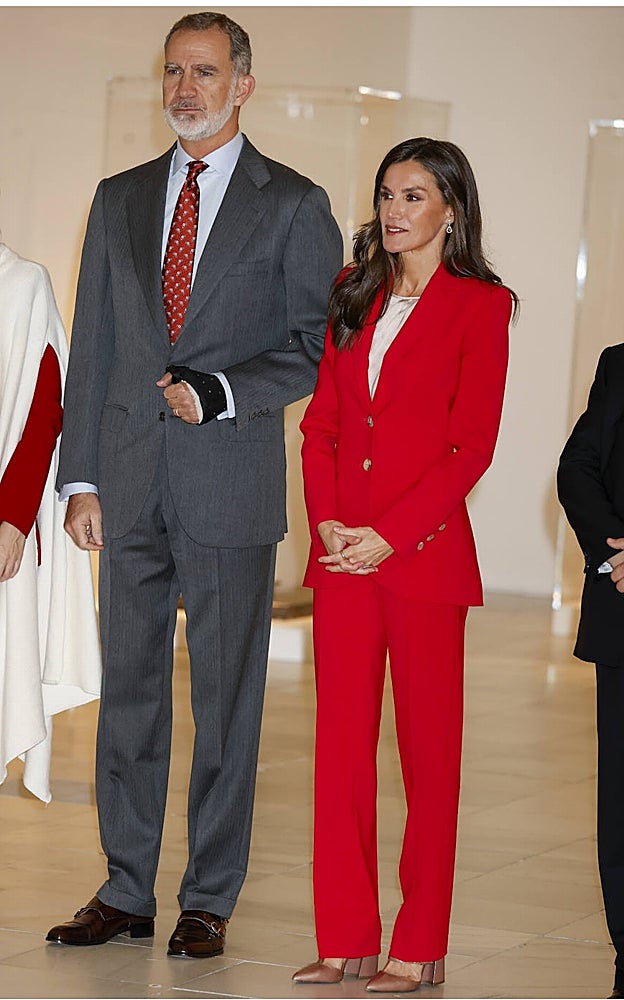 La Reina Letizia con traje rojo de Carolina Herrera, junto al Rey Felipe VI, en el Museo Reina Sofía de Madrid.
