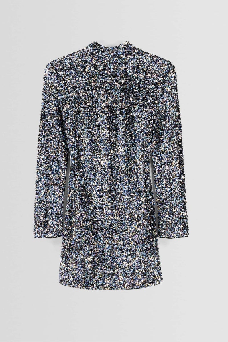 Bershka. Minivestido de lentejuelas en tonos plateados con manga larga, cuello Perkins y las hombreras marcadas que incluye un detalle en la espalda en terciopelo. Precio: 49,99€.