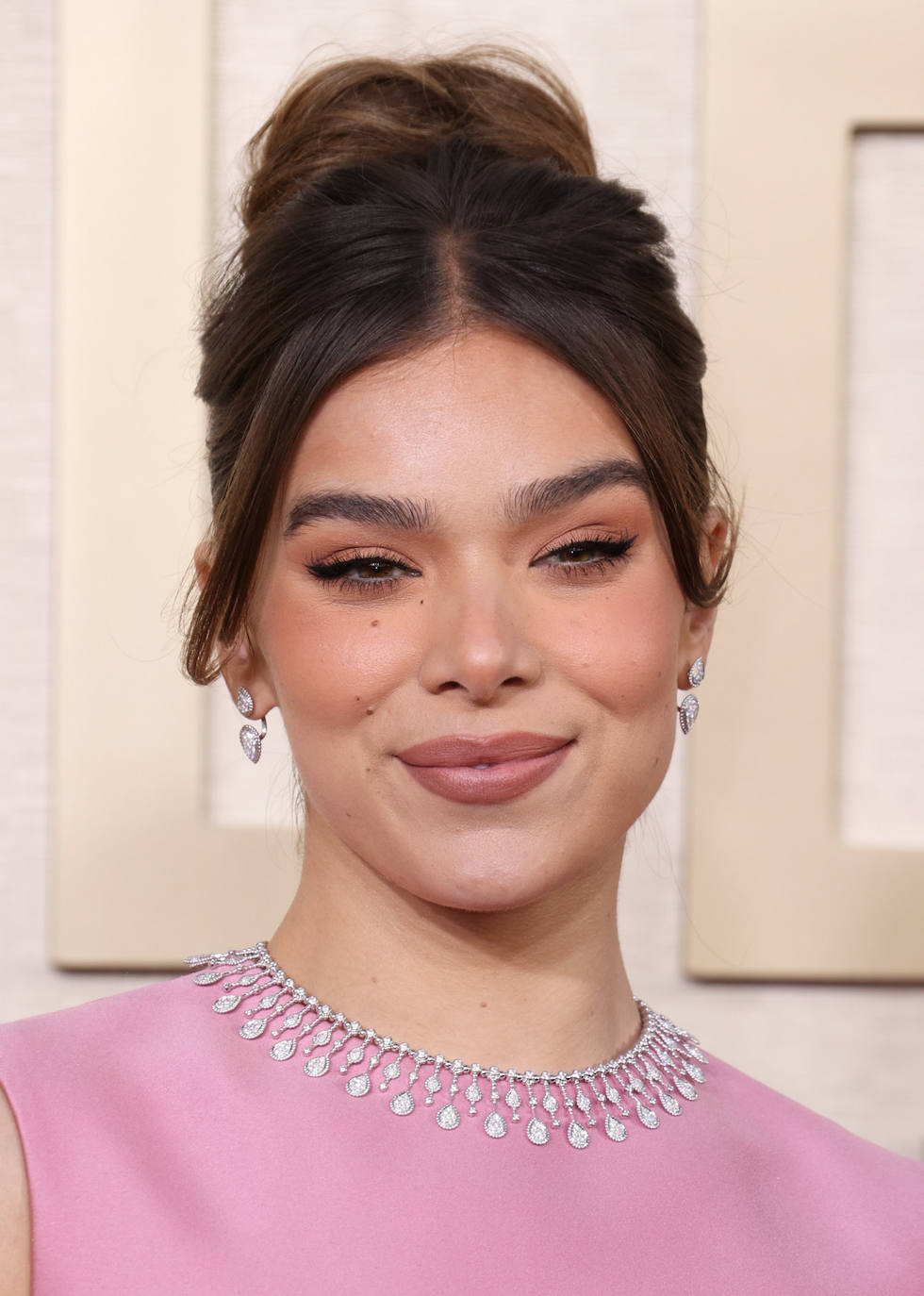 Hailee Steinfeld eligió un moño alto o 'top knot' que combinó con maquillaje en tonos rosas. 