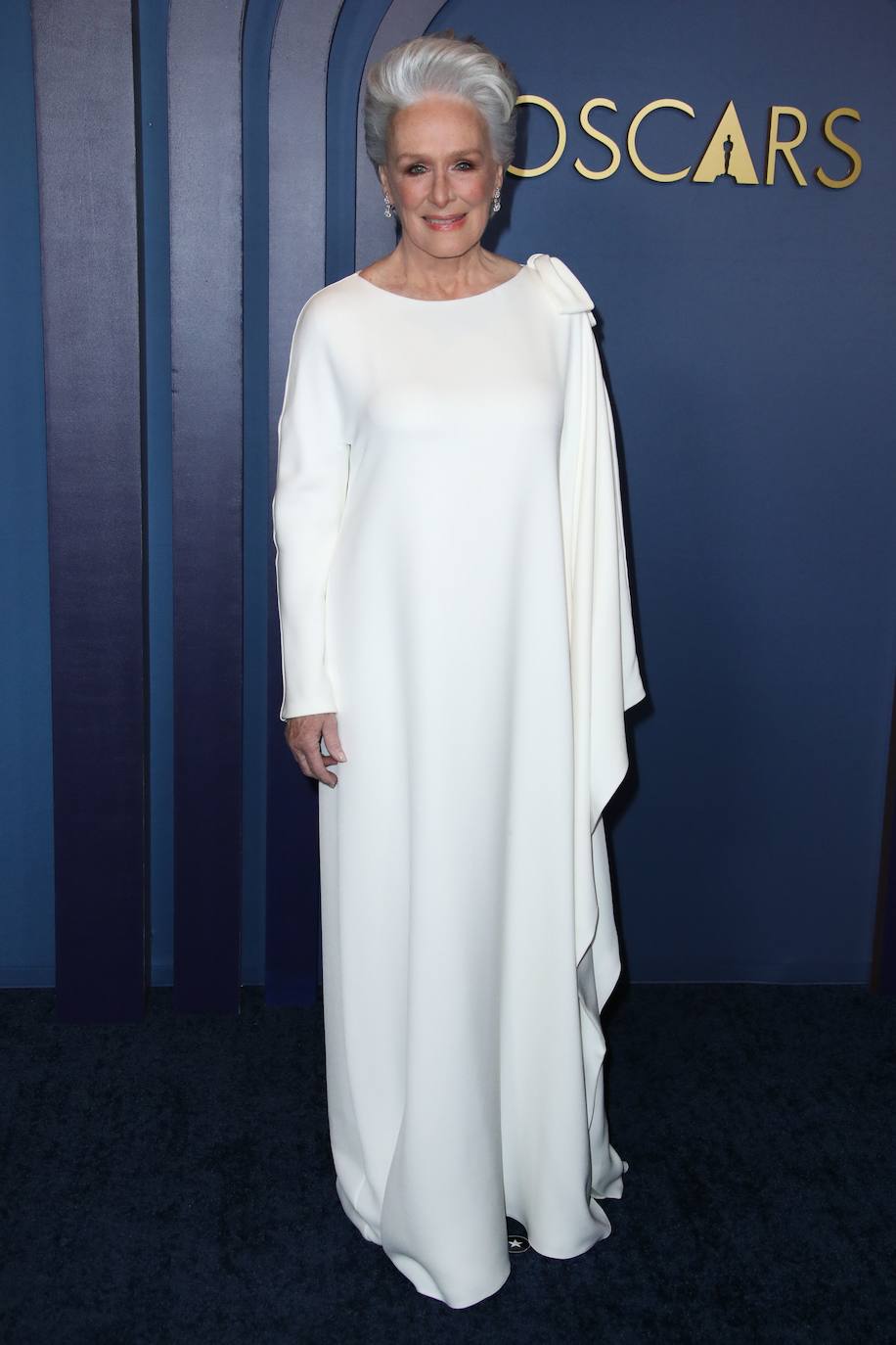 Glenn Close apostó por un elegante vestido en color blanco con una de sus mangas capeadas de Dior.