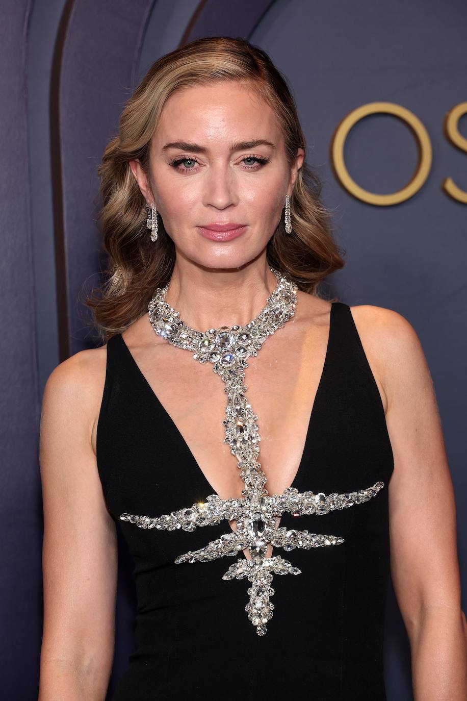 Emily Blunt con vestido negro con un espectacular detalle joya en forma de collar de Miu Miu.