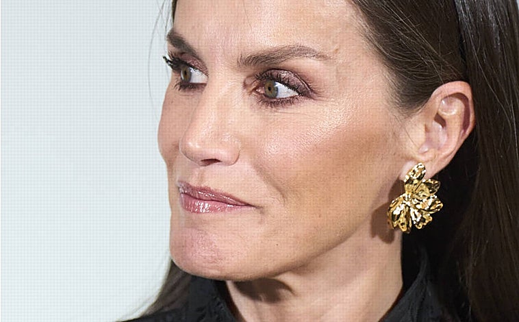 Imagen principal - La Reina eligió complementos en negro y dorado de Carolina Herrera para combinar con su traje negro de Dries Van Noten. Un estilismo perfecto. 