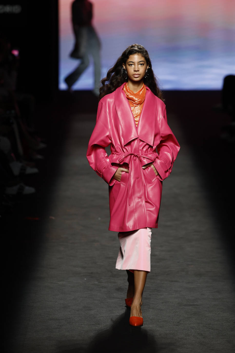 Isabel Núñez propone una colección muy femenina en la que conviven siluetas entalladas, con otras más oversize como este trench de cuero en color fucsia. 