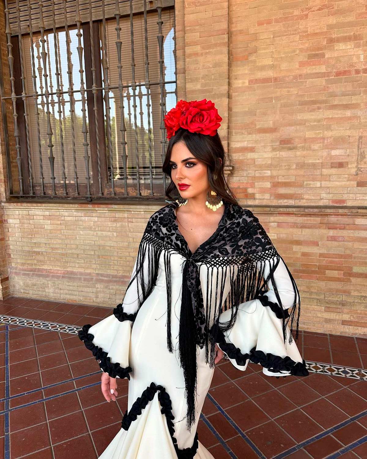 Alexia Rivas escogió un diseño bicolor de Sibilina Flamenca. En blanco y negro, lo combinó con un mantón semitransparente floral y flores rojas en el pelo. 