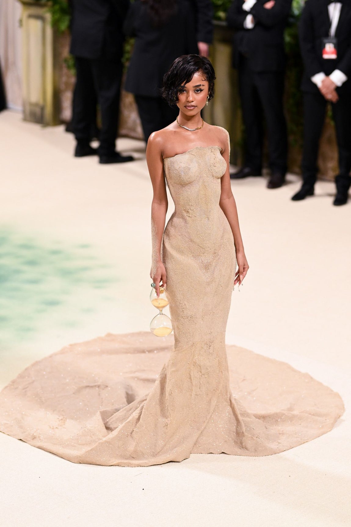 La cantante Tyla llevó uno de los vestidos más originales de la noche diseñado por Olivier Rousteing para Balmain y confeccionado con arena y microcristales. El diseño, con escote palabra de honor, y cola de organza, limitaba los movimientos de la sudafricano que protagonizó uno de los momentos más virales de la alfombra roja, al tener que ser llevada en volandas para subir las escaleras. 
