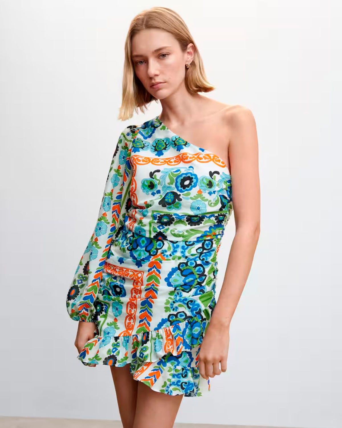 Vestido estampado corto con falda fruncida y escote asimétrico de una sola manga. 34.99 euros.