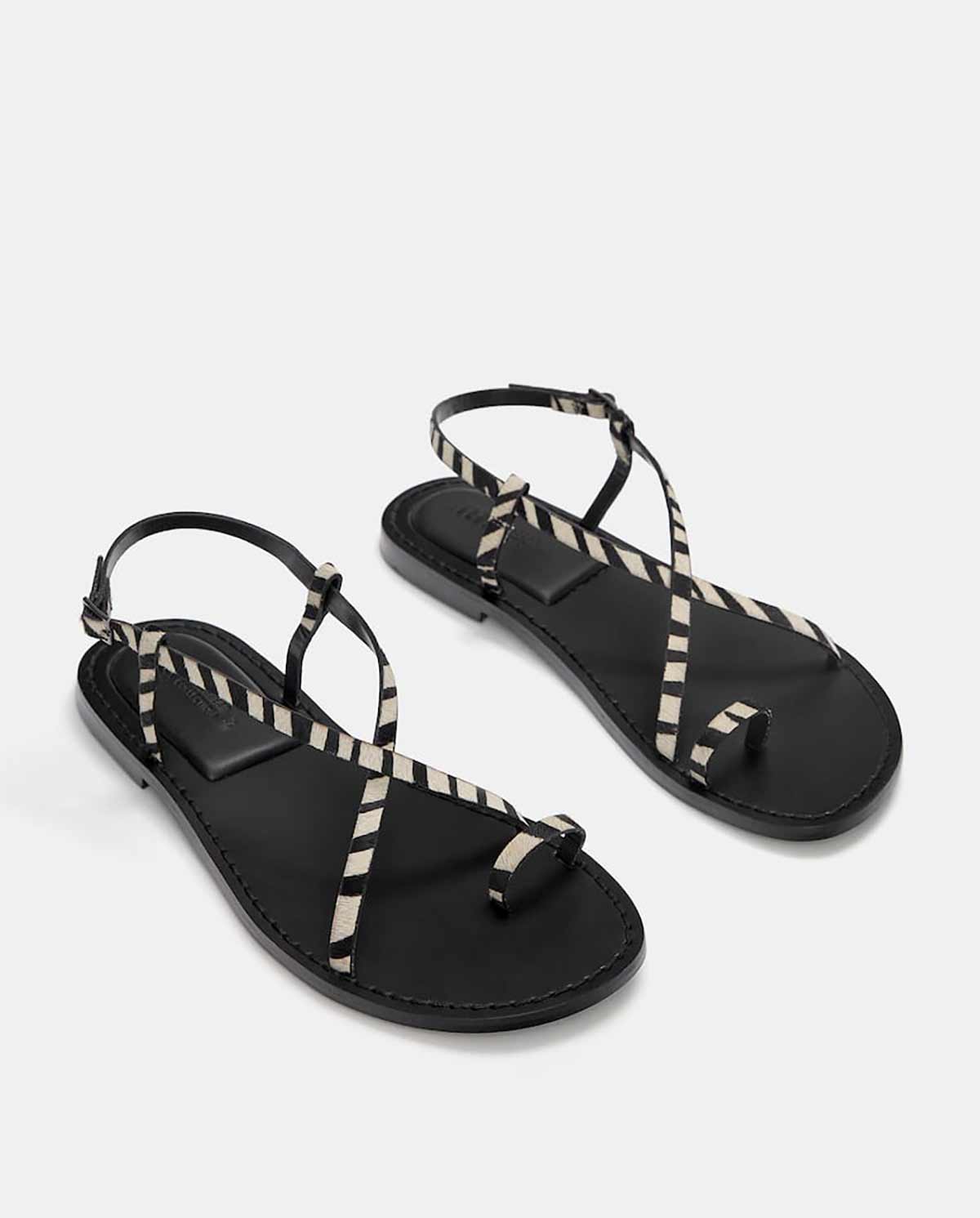 Sandalias planas con tiras de piel y estampado de cebra. 19.99 euros en las rebajas de Pull&Bear.