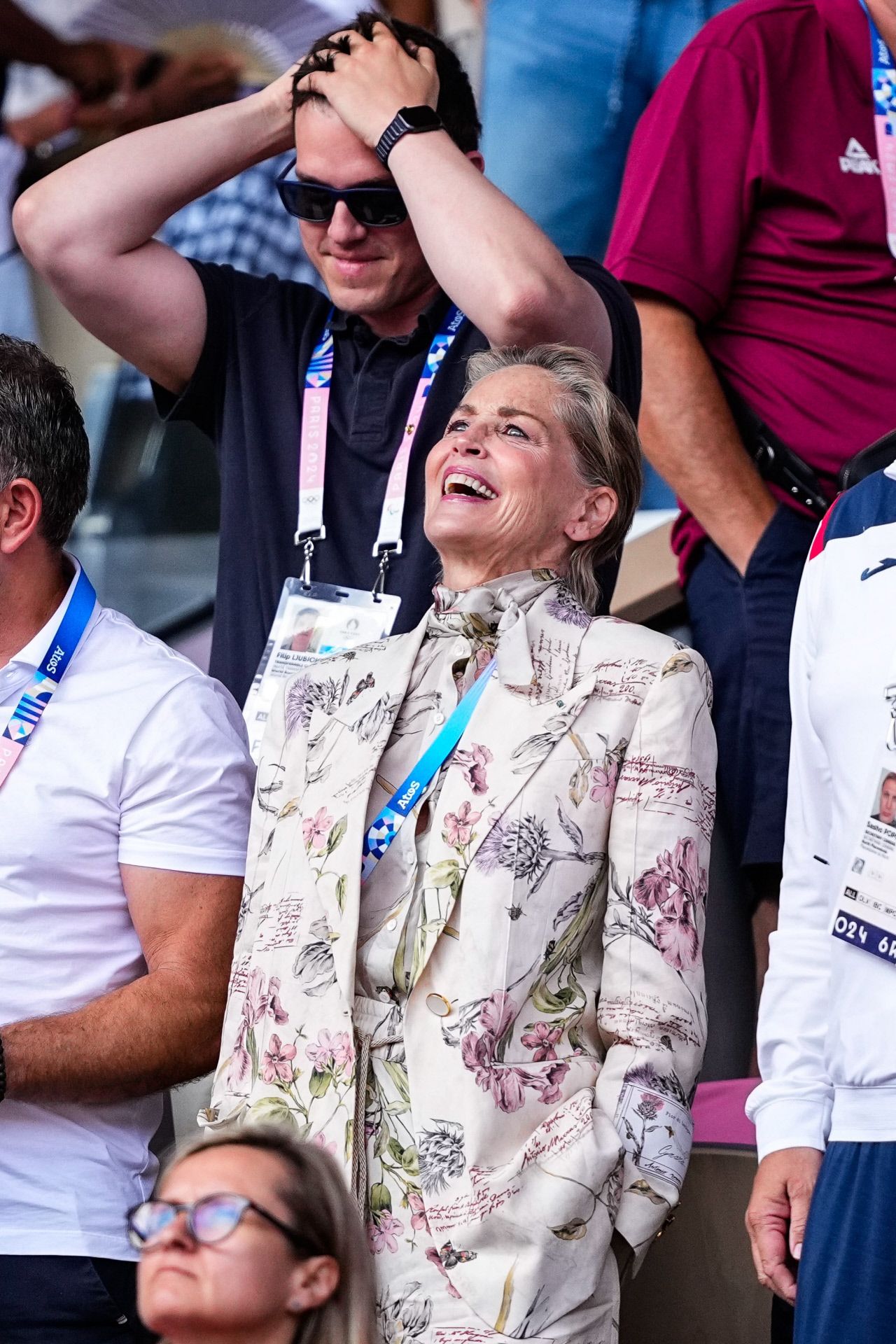 Sharon Stone no se perdió la final de tenis masculino y eligió un elegante traje de tres piezas, de pantalón, blazer y blusa con lazada en color crudo con estampado de motivos florales.