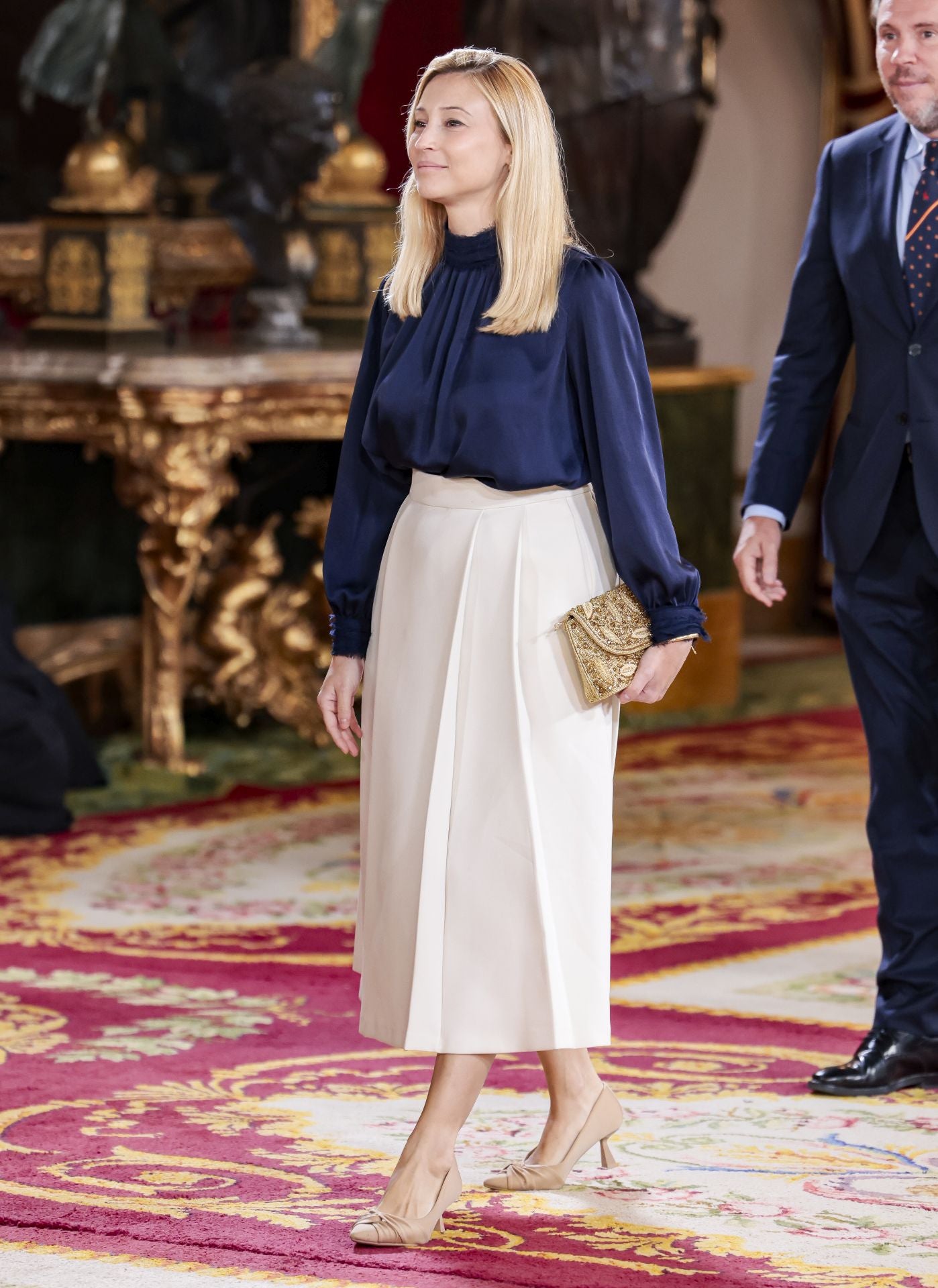 Eva Soria, esposa del Ministro Óscar Puentes, con falda blanca y blusa azul marino. 