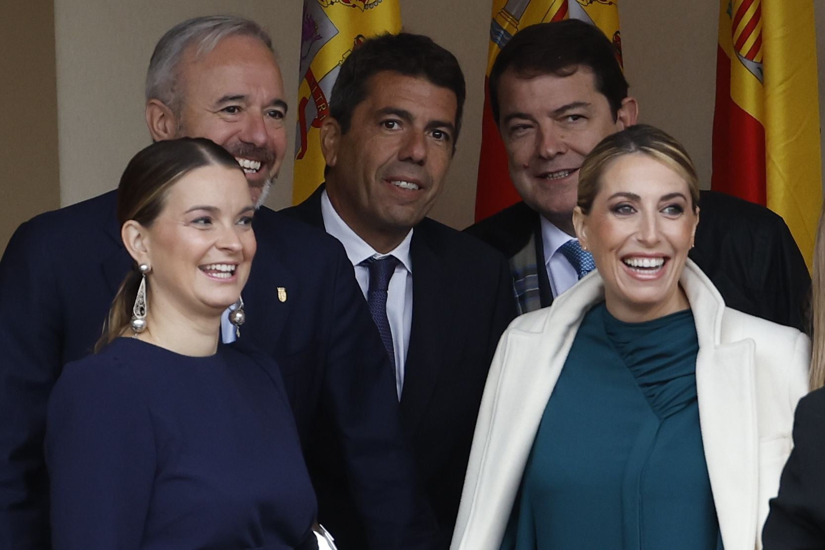 María Guardiola, presidenta de la Junta de Extremadura con abrigo blanco y vestido azul petróleo. 