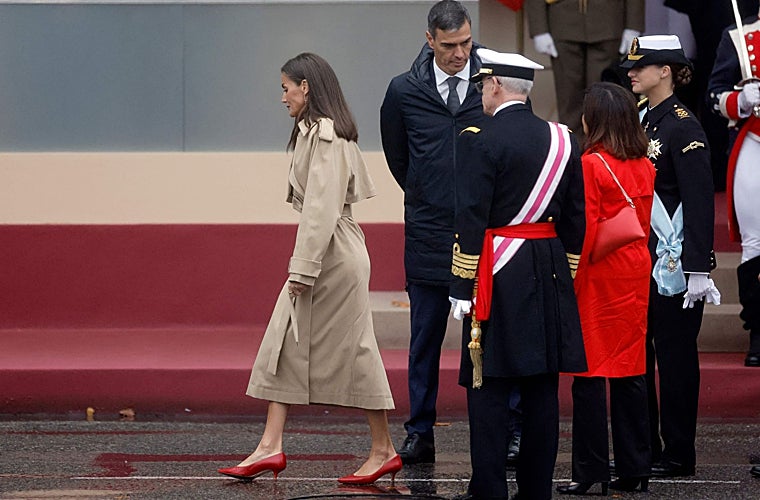 La Reina Letizia impecable con su trench y su conjunto rojo, mientras que Pedro Sánchez, parece un colegial en el patio a la espera de que suene el timbre para volver a clase.