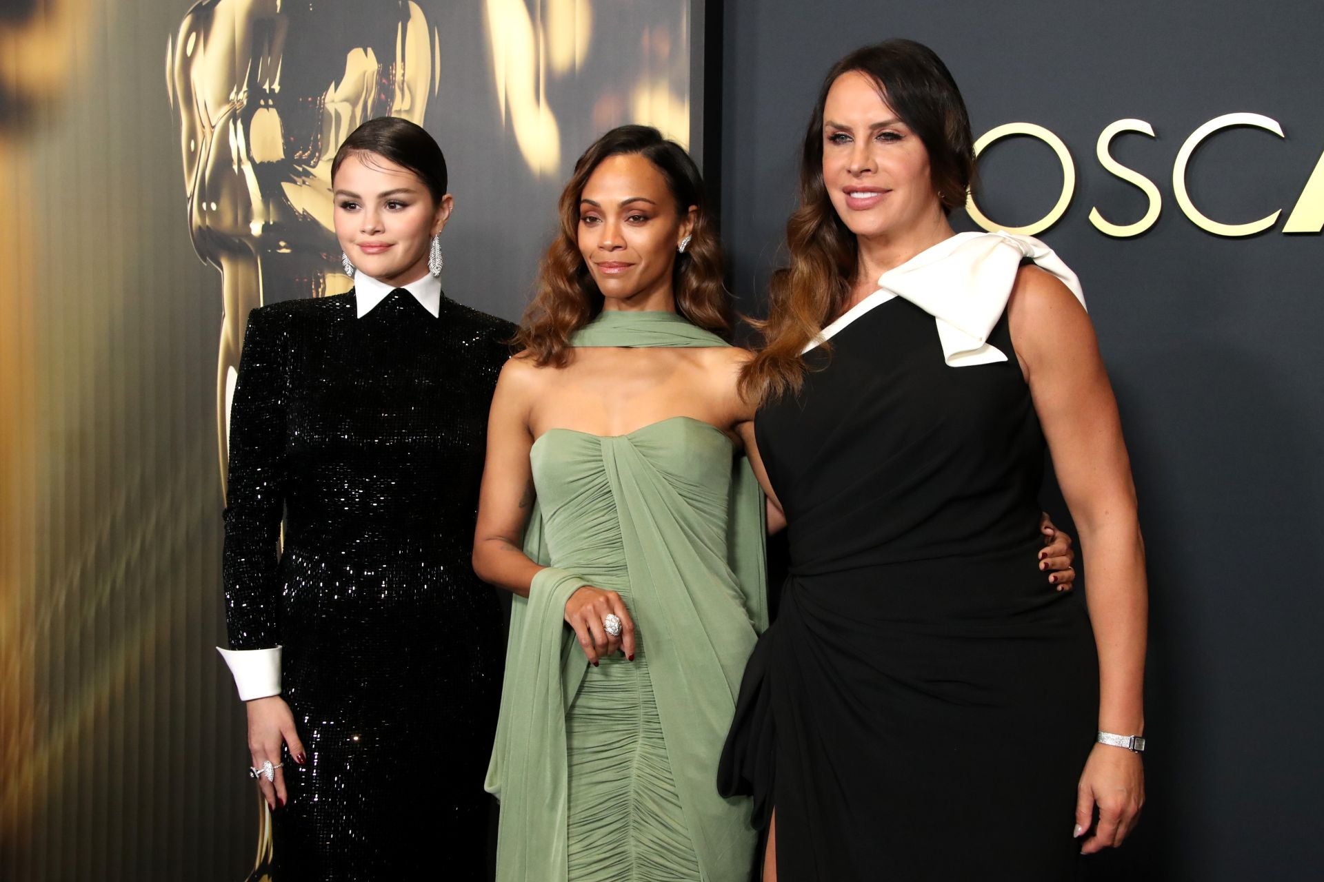 La española Karla Sofía Gascón escogió un vestido bicolor de escote asimétrico de Saint Laurent y posó en el photocall junto a Zoe Saldaña de Saint Laurent y Selena Gomez con un vestido repleto de lentejuelas negras con cuello y puños a contraste de Ralph Lauren.