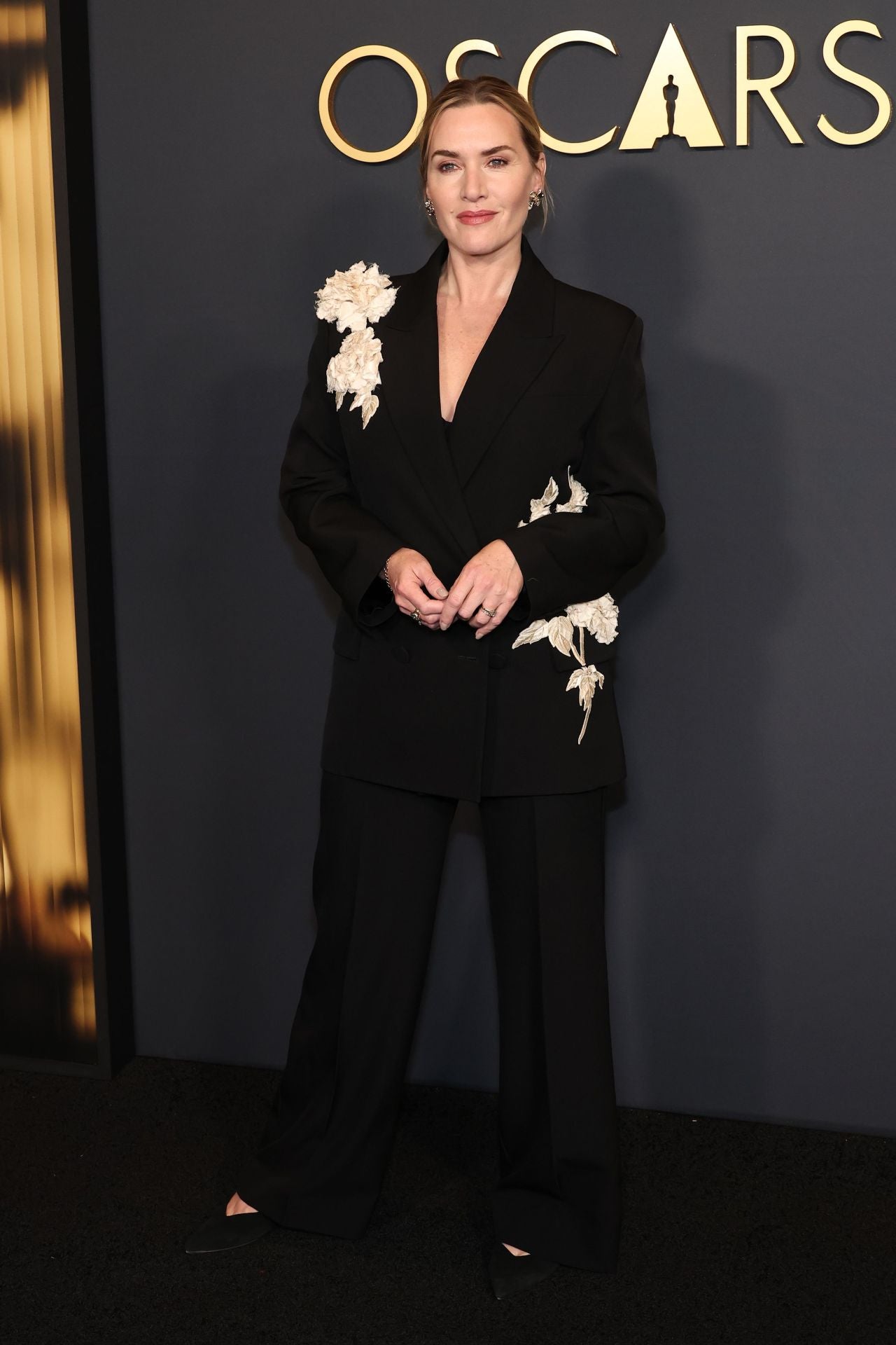 Otro de los looks destacados de la noche fue el de Kate Winslet, la actriz dejó los vestidos a un lado y en esta ocasión se decantó por un traje de chaqueta negro con llamativas flores blancas en 3D de la firma Erdem. 