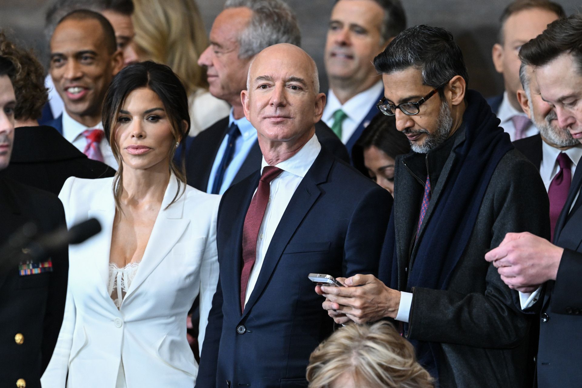 Las personas más ricas el mundo también han acudido a la investidura de Trump. Jeff Bezos, de traje, acompañado de su pareja, Lauren Sánchez, con un traje sastre blanco debajo del que asomaba un top de encaje, también en blanco. 