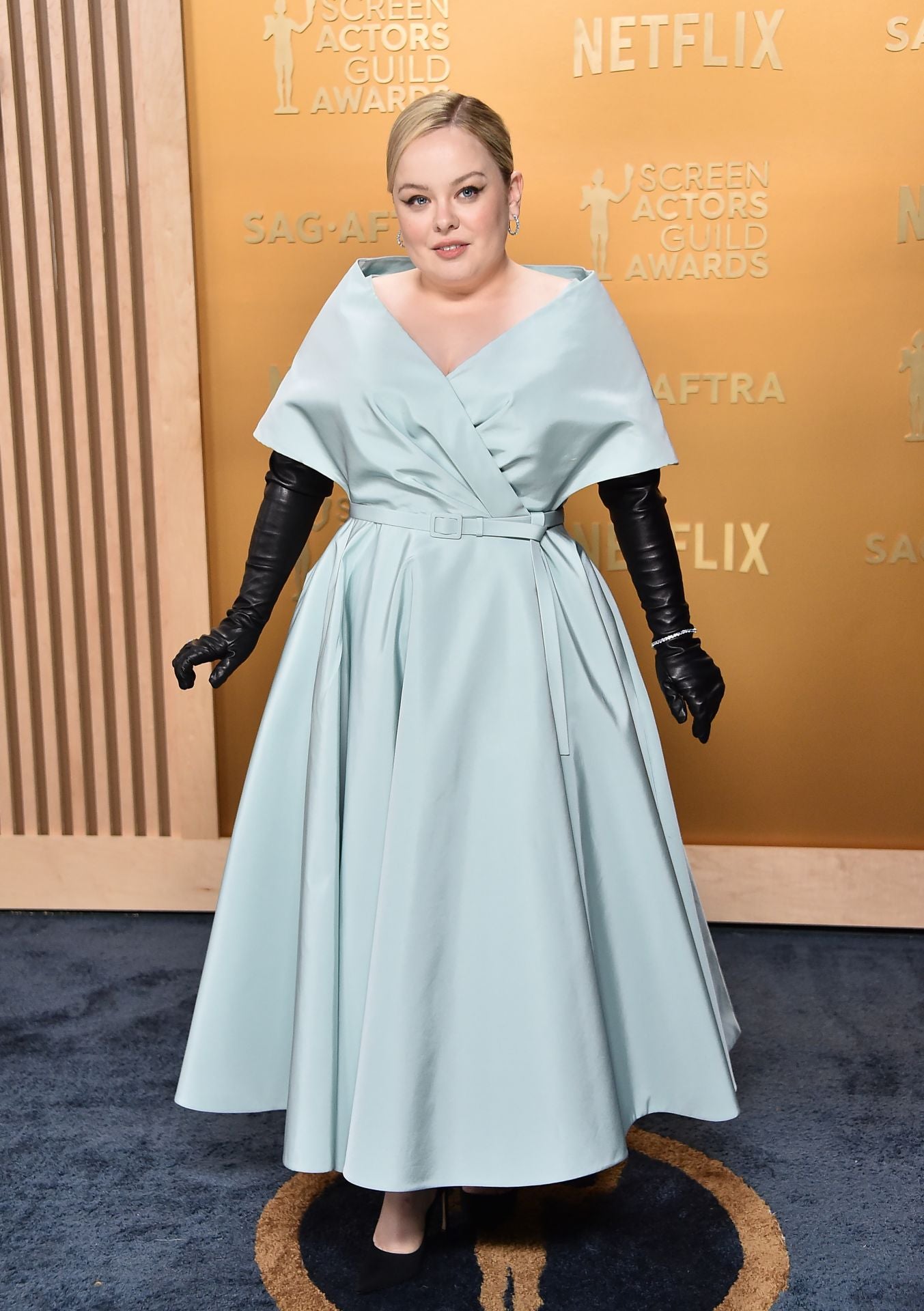 La actriz Nicola Coughlan con vestido de Dior en azul menta y largos guantes negros.