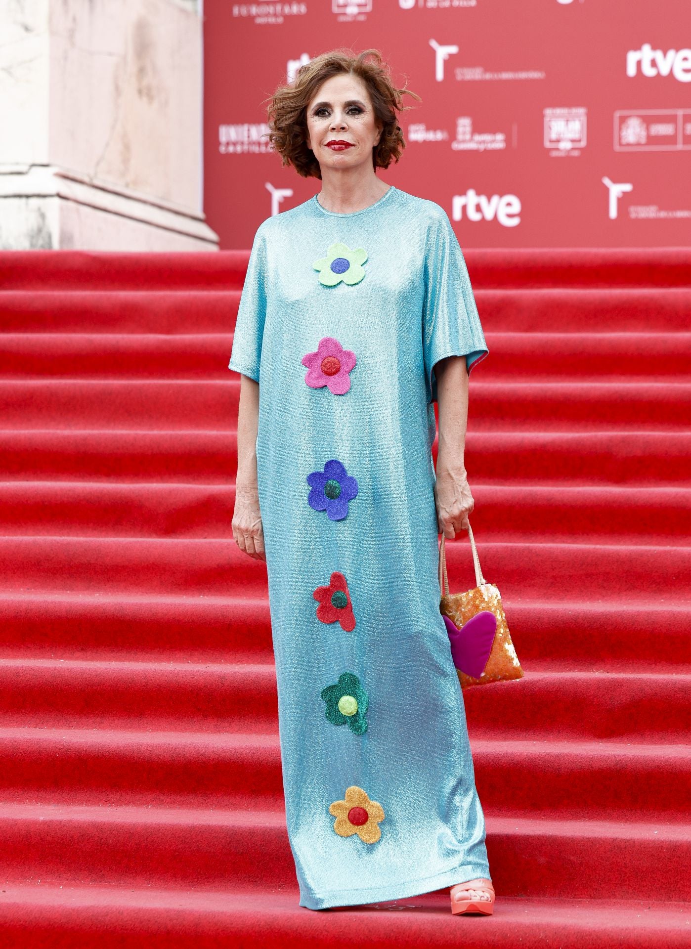 La diseñadora Ágatha Ruiz de la Prada con uno de los vestidos de su colección en esta ocasión con fondo azul cielo. 