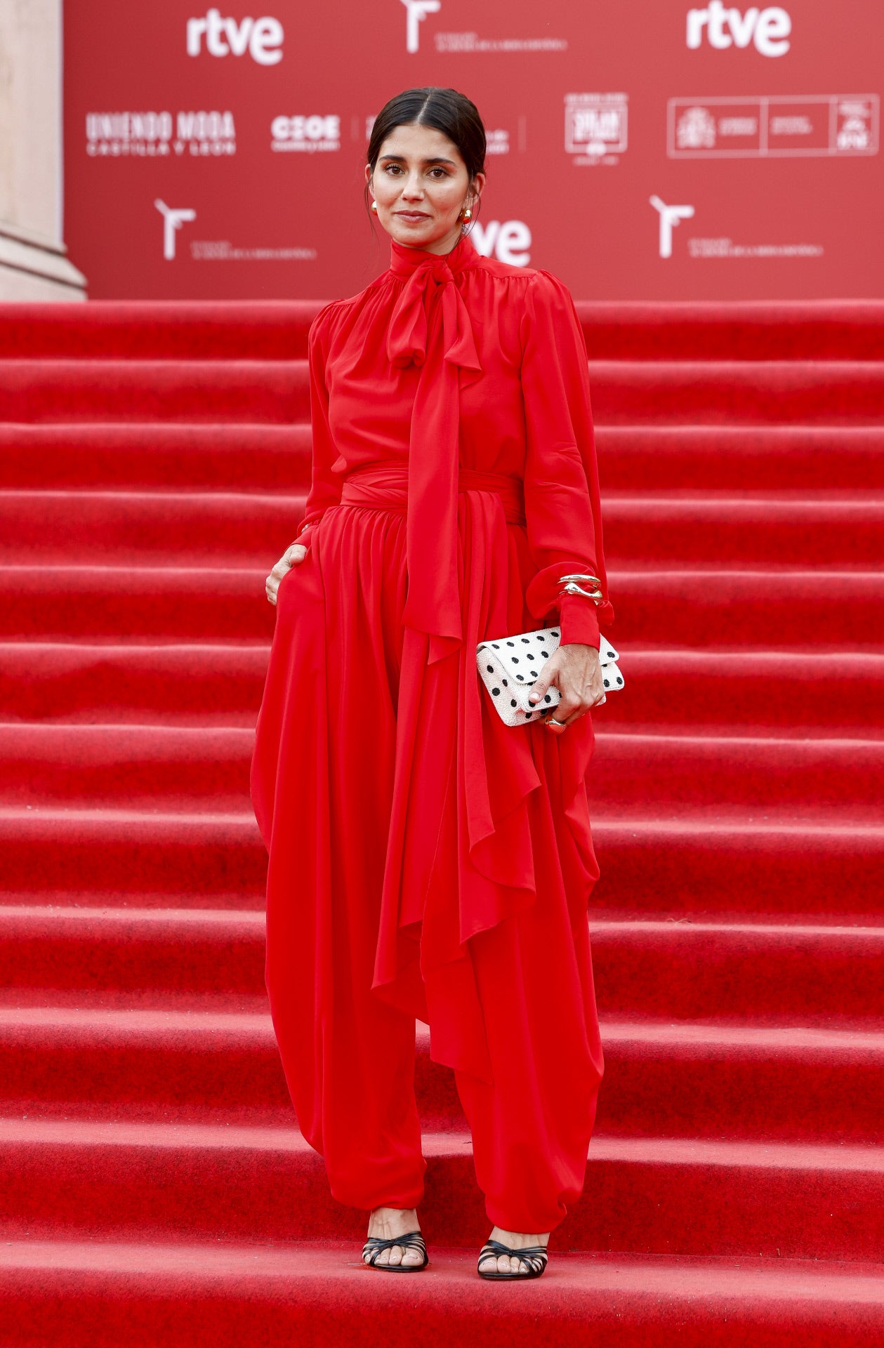 María G. de Jaime  con un traje rojo de Pedro del Hierro combinado con un bolso de mano blanco y negro.