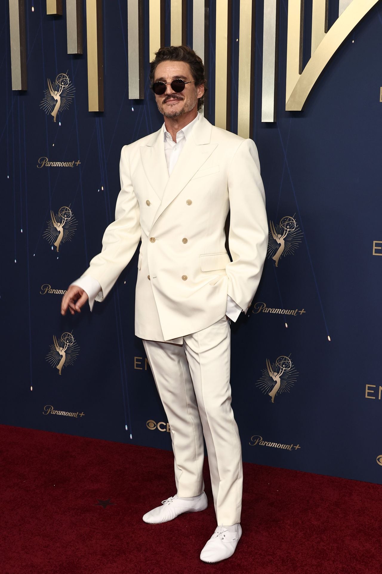 Pedro Pascal asistió de impoluto blanco de pies a cabeza con traje de chaqueta de doble botonadora y zapatillas con cordones. 